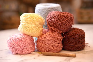 El sanatları okulunun stüdyosunda olduğu kadar gruptaki örgü ipliği de arka planda. İğneler el yapımı hobi için masanın üzerinde. Pamuklu iplikle örgü iplik torbası..