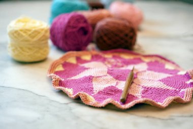 El sanatları okulunun stüdyosunda olduğu kadar gruptaki örgü ipliği de arka planda. İğneler el yapımı hobi için masanın üzerinde. Pamuklu iplikle örgü iplik torbası..