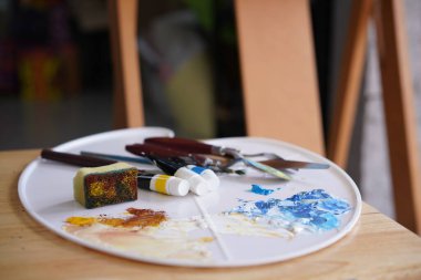 Palet ve fırçayla çizim tezgahında akrilik deniz ve plaj resimleri. Fırça ve bıçak paleti tekniğiyle altın el boyama üzerinde mavi dalga. Tablodaki sanat.