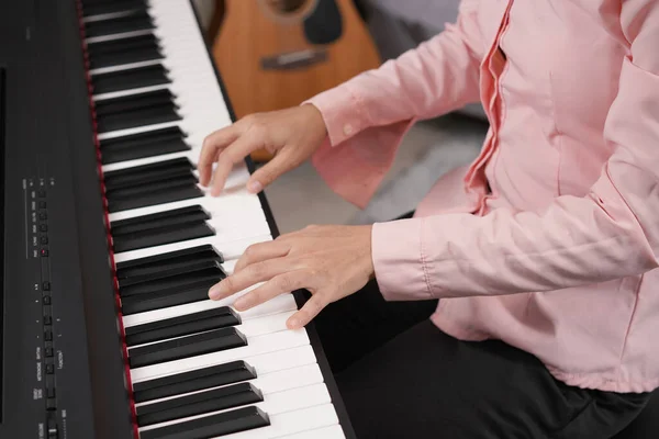 大人の女性はノートシートで電子ピアノを演奏します ニュービー ピアニストの練習と歌の演奏方法 — ストック写真