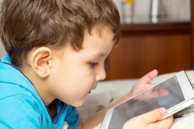 Erkek yatakta yatıyordu tablet ile