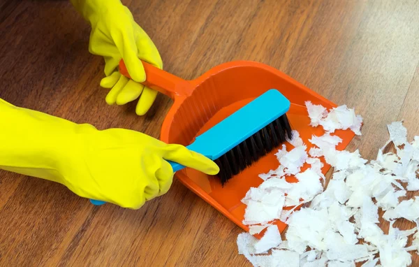 Chica barriendo el suelo con un cepillo en la pala . — Foto de Stock