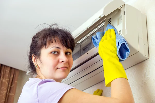 A rapariga que faz a limpeza. Limpe com um condicionador de pano úmido — Fotografia de Stock