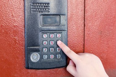 El eve girmek için dahili telefona basıyor..