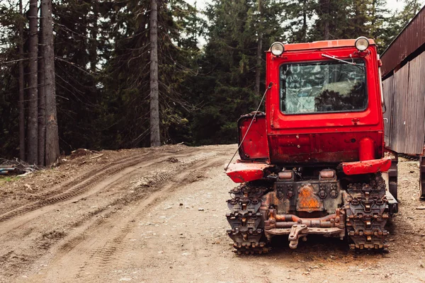 Capó tractor y ruedas grandes en camino de suelo natural en bosque de primavera —  Fotos de Stock