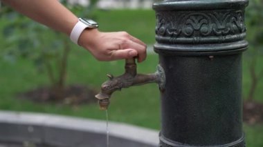 Yaz günü parkta ellerini yıkayan bir kadın. Koronavirüs salgını sırasında viral hastalıkların önlenmesi için önlemler.