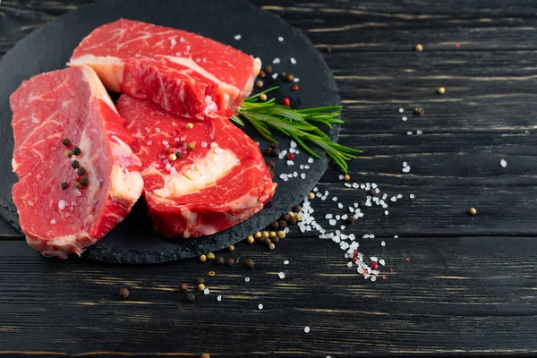 Drie Stukken Sappig Rauw Rundvlees Met Rozemarijn Een Stenen Snijplank — Stockfoto