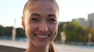 Dışarıda gülümseyen bir kadın. Gülen yetişkin bir kadının portresi. Yavaş çekim