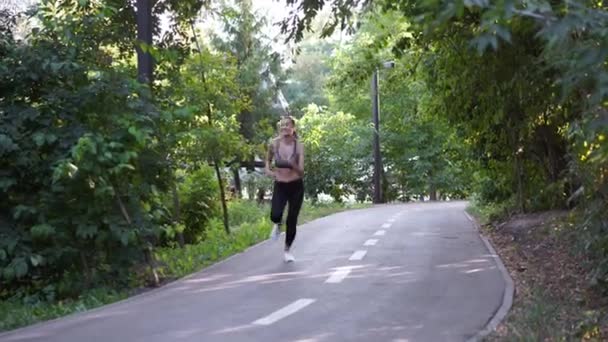 Donna che corre asfalto strada estate parco — Video Stock