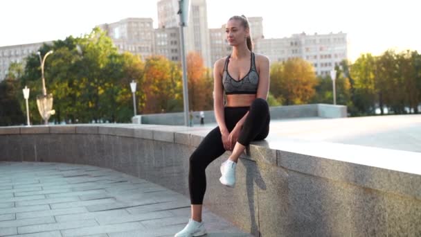 Žena běžec odpočívá posezení po cvičení městské město pozadí — Stock video