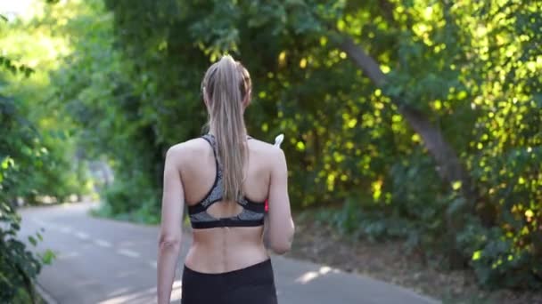 Effetto tenuto in mano. Donna bere acqua bottiglia rossa dopo l'allenamento del mattino. — Video Stock