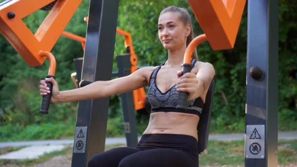 スポーツ女子トレーニングマシン屋外ジム夏の公園 — ストック動画