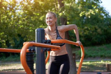 Spor bayan spor dalış egzersiz makinesi açık hava spor salonu yaz parkı Kafkasyalı kadın spor kıyafetleri giymiş Simülatör spor sahasında. Sağlıklı yaşam tarzı kavramı