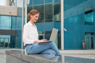 İş kadını dizüstü bilgisayar başarılı kadın iş adamı dışarıda şirket binası dış mimarisi Kafkasyalı profesyonel iş kadını orta yaş ekommerce anlaşması Online bankacılık