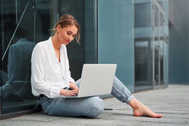 İş kadını başarılı kadın iş adamı dışarıda şirket binası dışında dizüstü bilgisayarı olan hoş beyaz iş kadını orta yaşlı iş kadını online bankacılık