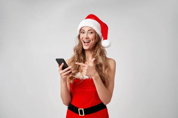 Woman Christmas Santa Hat Fehér Stúdió Háttér Okostelefonnal Kezében Gyönyörű — Stock Fotó