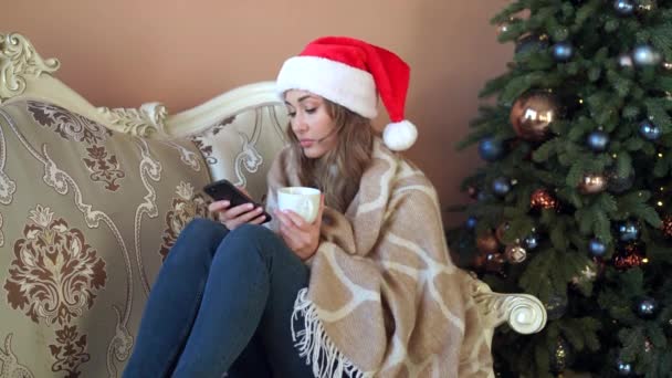 Woman stay at home during quarantine. Sick ill person with headache and runny nose wrapped blanket sitting sofa Christmas Holidays with sickness. — Stock Video