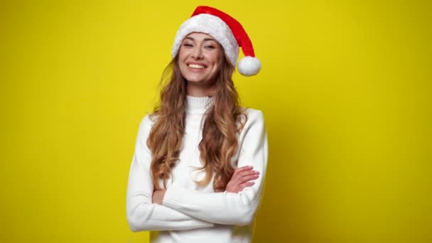 Woman Christmas Santa Hat sweater yellow studio background — ストック動画