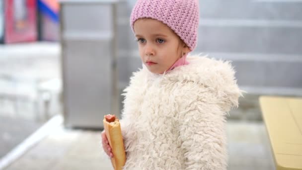 A kislányok hot dogot esznek a szabadban Őszi szezon — Stock videók