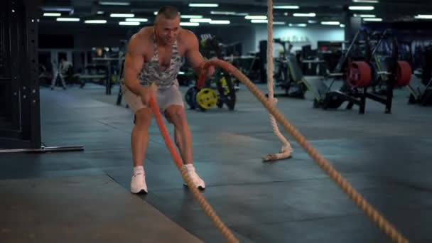 Bodybuilder athlétique musclé fitness modèle entraînement bataille corde gymnase — Video