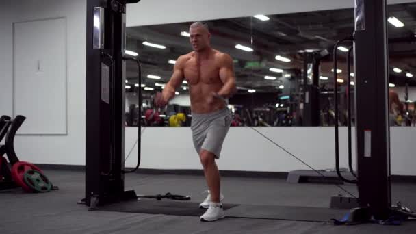 Muscular atlético culturista de pie entrenamiento pecho y hombros músculos en el equipo de fitness — Vídeos de Stock