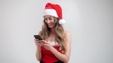 Noel Baba 'nın Beyaz Atölyesi' nin arka planı akıllı telefonlu bir kadın.