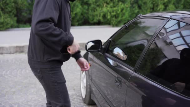 Autólopás tolvaj ellopni autó betörés ajtó bűnügyi munka betörő Hijacks Auto tolvaj fekete maszk kapucnis próbál betörni jármű csavarhúzó Street bűnözés erőszak gengszter rabló autó — Stock videók