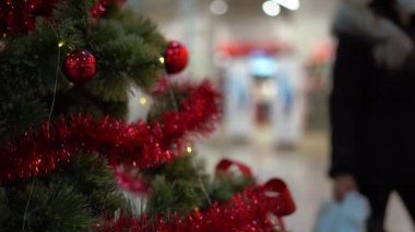 Noel ağacı ayakta duran alışveriş merkezleri arka planda yürüyen insanları bulanıklaştırıyor