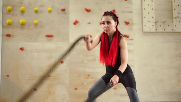Gimnasio batalla cuerda mujer entrenamiento de resistencia Atleta chico fitness ejercicio de resistencia entrenamiento en interiores. — Vídeos de Stock