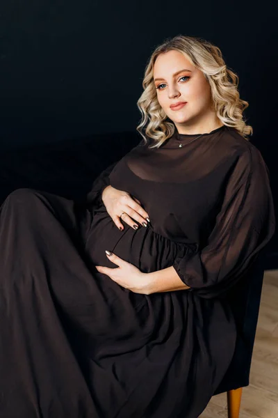 エレガントな黒のドレスで妊娠中の女性屋内スタジオ黒壁の背景ブロンド原因アジアの中年女性6ヶ月の妊娠 — ストック写真