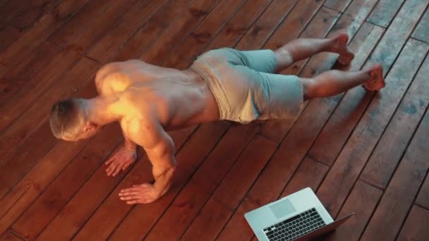 Ampla tiro vista superior atlético cara fazendo push-up exercícios em casa — Vídeo de Stock