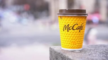 Ukrayna, Kiev Şubat 2021 Elinde McCafe kahvesi olan sarı kağıt bardak