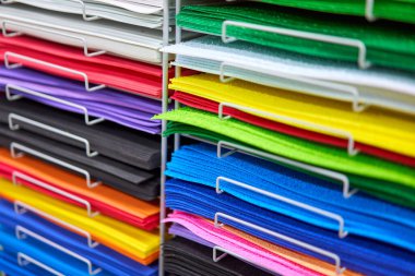 Yaratıcı tasarım çalışmaları için çarşaflar renkli karton. Mağazada çok renkli çizim kağıtları biriktirir. Rafta satılık renkli sanat kağıtları var.