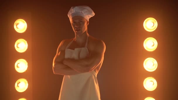 Portret kucharza ubranego w biały fartuch i czapkę szefa kuchni na zadymionym tle — Wideo stockowe