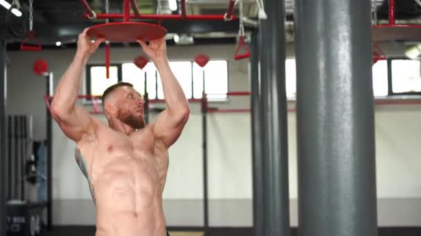 男子攀爬体操运动员在室内训练臂力耐力。理想的身体，完美的腹肌，赤身裸体 — 图库视频影像