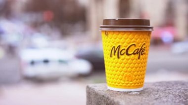 Ukrayna, Kiev Şubat 2021 Elinde McCafe kahvesi olan sarı kağıt bardak