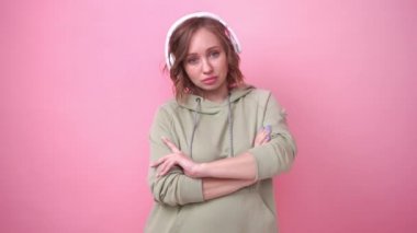 Mutlu dişler gülümser kadın pembe arka planda müzik kulaklıkları dinler.