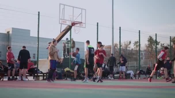 Kharkov, Ucrania abril 2021 Jóvenes activos jugando streetball en un hermoso campo de deportes al aire libre. — Vídeo de stock