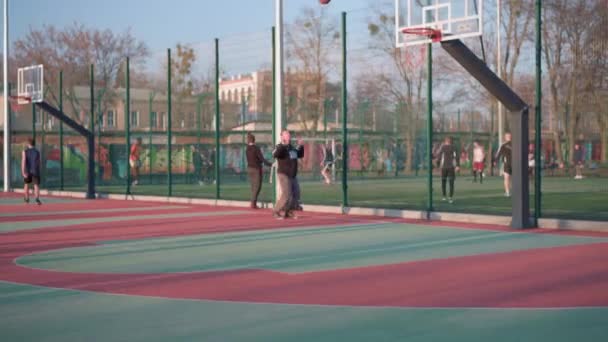 Kharkov, Ucrania abril 2021 Jóvenes activos jugando streetball en un hermoso campo de deportes al aire libre. — Vídeos de Stock