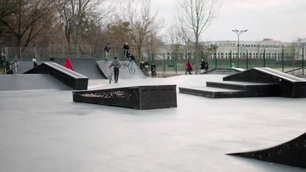 ハリコフ,ウクライナ4月2021若い人たちがスケートボードやスクーターをローラーブレードスケートボード公園でアクティブなレジャー — ストック動画