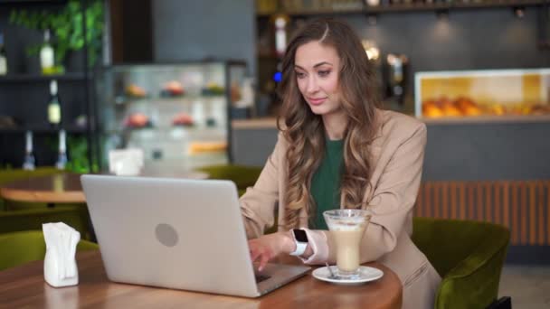 Владелец ресторана Business Woman использует элегантный брючный костюм на ноутбуке, сидя за столом в ресторане со стойкой бара — стоковое видео