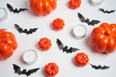 Cadılar Bayramı arka planı, turuncu dekoratif plastik balkabağı siyah yarasa mum yuvarlak beyaz karton Şükran Günü tebrik kartı deseni