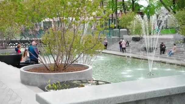 Ukraine, Kharkov 10 May 2021 fountain in the center of the city of Kharkov lake with water flowering trees spring People walking rest sitting on the steps on benches — Stock Video