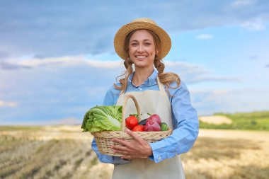 Woman farmer straw hat holding basket vegetable onion tomato salad cucumber standing farmland smiling Female agronomist specialist farming agribusiness Happy Girl dressed apron cultivated wheat field clipart