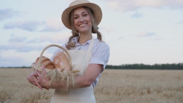 Női mezőgazdasági termelő álló búza mezőgazdasági területen Nő pék gazdaság fonott kosár kenyér termék — Stock videók