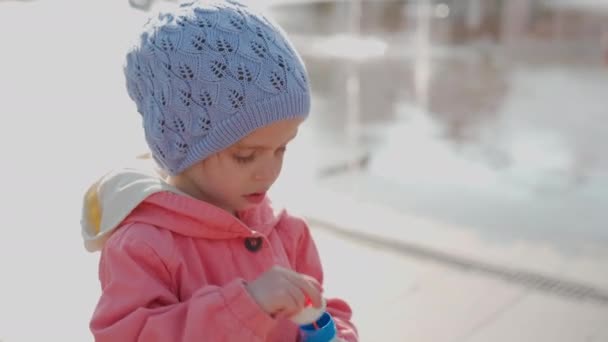 Детство. Маленькая девочка дует мыло болтает на открытом воздухе в парке Осенний сезон Кавказский ребенок женщина одета голубая шляпа и розовый пиджак — стоковое видео