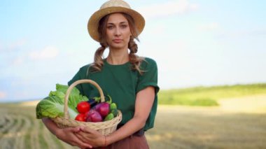Kadın çiftçi hasır şapka önlüğü ayakta duran tarım arazisi gülümseyen tarımcı kadın tarım uzmanı mutlu Kafkas işçi tarlası