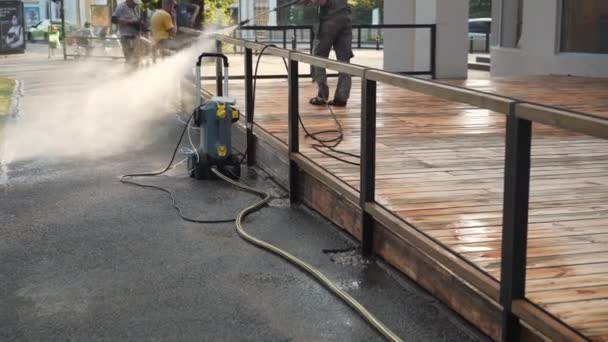 Oekraïne, Kharkov mei 2021 man schoonmaak terras met een wasmachine - hogedrukreiniger op houten terras oppervlak — Stockvideo