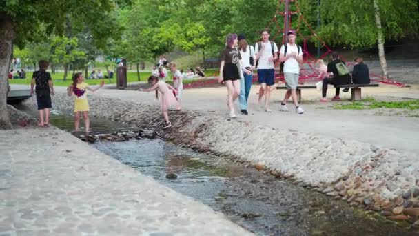 Ukraine, Kharkov May 2021 Children playing artificial stream in city park Sargin Yar — Stock Video