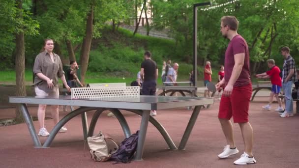 Ukraine, Charkow Mai 2021 viele Menschen spielen Tischtennis im Freien Stadtpark Gesunder Lebensstil aktive Freizeit in der Natur — Stockvideo